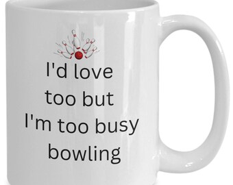 Pode incluir: Caneca de café de cerâmica branca com um gráfico preto de pinos de boliche e uma bola de boliche. O texto na caneca diz "Eu adoraria, mas estou muito ocupado jogando boliche."