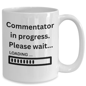 May include: White ceramic coffee mug with black text that reads "Commentator in progress. Please wait... LOADING..." with a progress bar graphic.