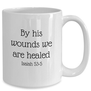 May include: White ceramic coffee mug with black text that reads "By his wounds we are healed Isaiah 53-5".