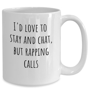 Peut inclure: Une tasse à café en céramique blanche avec du texte noir qui dit "J'aimerais bien rester et discuter, mais le rap appelle."
