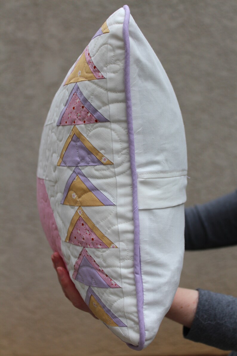 This shows the side of the pillow and the light purple piping that runs around the entire edge of the pillow.