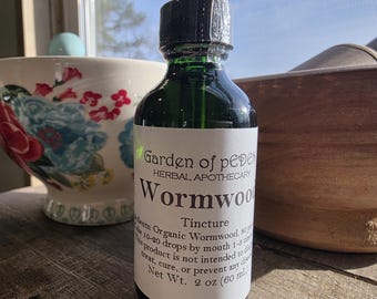 May include: A glass bottle of green liquid labeled "Garden of Eden Herbal Apothecary Wormwood Tincture". The label also includes the text "Ingredients: Organic Wormwood, so take 10-20 drops by mouth 1-3 times daily. This product is not intended to diagnose, treat, cure, or prevent any disease. Net Wt. 2 oz (60 ml)"