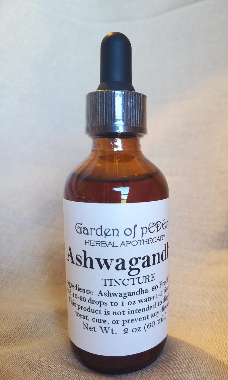 May include: A brown glass bottle with a dropper top and a white label that reads "Garden of pedes HERBAL APOTHECARY Ashwagandha TINCTURE Ingredients: Ashwagandha, 80 Proof 10-20 drops to 1 fl oz water 1-3 times daily. This product is not intended to diagnose, treat, cure, or prevent any disease. Net Wt. 2 fl oz (60 ml)"