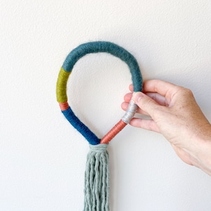 Knotted rope loop wall hanging, Tassel wrapped rope wall art, Minimalist macrame yarn knot design, Housewarming gift