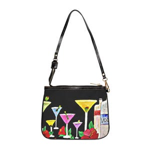 May include: Black shoulder bag with a watercolor design of cocktails, including martinis and other mixed drinks. The bag features a black strap and a zipper closure. The design includes bottles labeled "GIN" and "VOD".