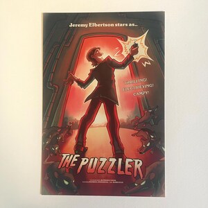 May include: A movie poster for "The Puzzler" starring Jeremy Elbertson. The poster features a cartoon man in a suit holding a lit match in front of a red doorway. The text "THRILLING! ELECTRIFYING! CAMPY!" is written in white on a red background. The poster is surrounded by cartoon rats.