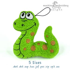 May include: A plush green snake toy with a smiling face and brown spots. The toy has a black loop for hanging and the text "machine embroidery designs" is visible. The text "5 Sizes" and file extensions are also present.