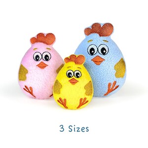 May include: Three plush toy chicks in different sizes. The largest chick is blue, the middle chick is yellow, and the smallest chick is pink.  The chicks have embroidered eyes, beaks, and feet.