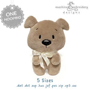 May include: A light brown plush dog toy with a cream bow. The dog has a black nose and embroidered eyes. The image includes the text "ONE HOOPING" and "5 Sizes". The design is for machine embroidery.