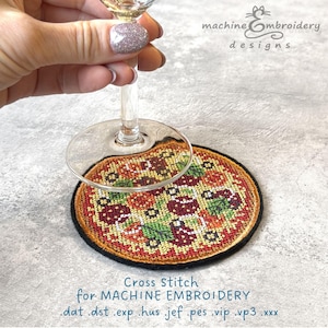 May include: A cross-stitched pizza coaster with a black border, topped with red, green, and brown cross-stitch details. A wine glass rests above the coaster. Text reads "Cross Stitch for MACHINE EMBROIDERY".