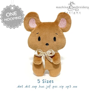 Puede incluir: Un peluche marrón con forma de ratón con orejas grandes y un lazo color crema. El ratón tiene el interior de las orejas rosas y ojos negros. La imagen incluye el texto "ONE HOOPING", "machine embroidery designs" y "5 Sizes".