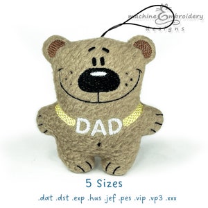 May include: Brown plush teddy bear with a gold chain and the word "DAD" embroidered on its chest. The bear has a black nose and a white smile.