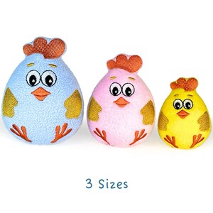 May include: Three plush chick toys in different sizes. The largest chick is light blue with yellow accents, the middle chick is pink with yellow accents, and the smallest chick is yellow with orange accents.  All three chicks have embroidered eyes and beaks.
