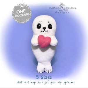 May include: A white plush seal toy holding a pink heart, featuring black embroidered eyes and a nose. Text on the image includes "ONE HOOPING", "machine embroidery designs", "5 Sizes", and a list of file formats: .dat .dst .exp .hus .jef .pes .vip .vp3 .xxx.