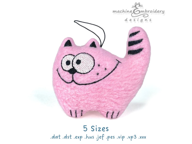 May include: A pink cat-shaped plush toy with embroidered facial features and a striped tail. The cat has a smiling expression and a black hanging string. The text "machine embroidery designs" is in the upper right corner.