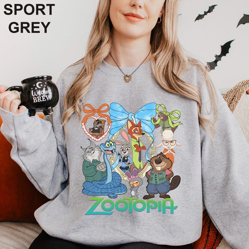 A woman wearing a grey sweatshirt with a cartoon character design, holding a black mug with the text "I love Brew" printed on it.