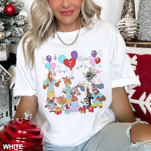 A woman wearing a white t-shirt with a graphic design of cartoon animals celebrating a birthday.