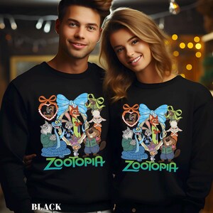 A man and a woman are standing next to each other, both wearing black sweatshirts with a colorful cartoon character design featuring the character Zootopia.
