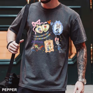 A man wearing a gray t-shirt with a graphic design featuring cartoon animals and text.