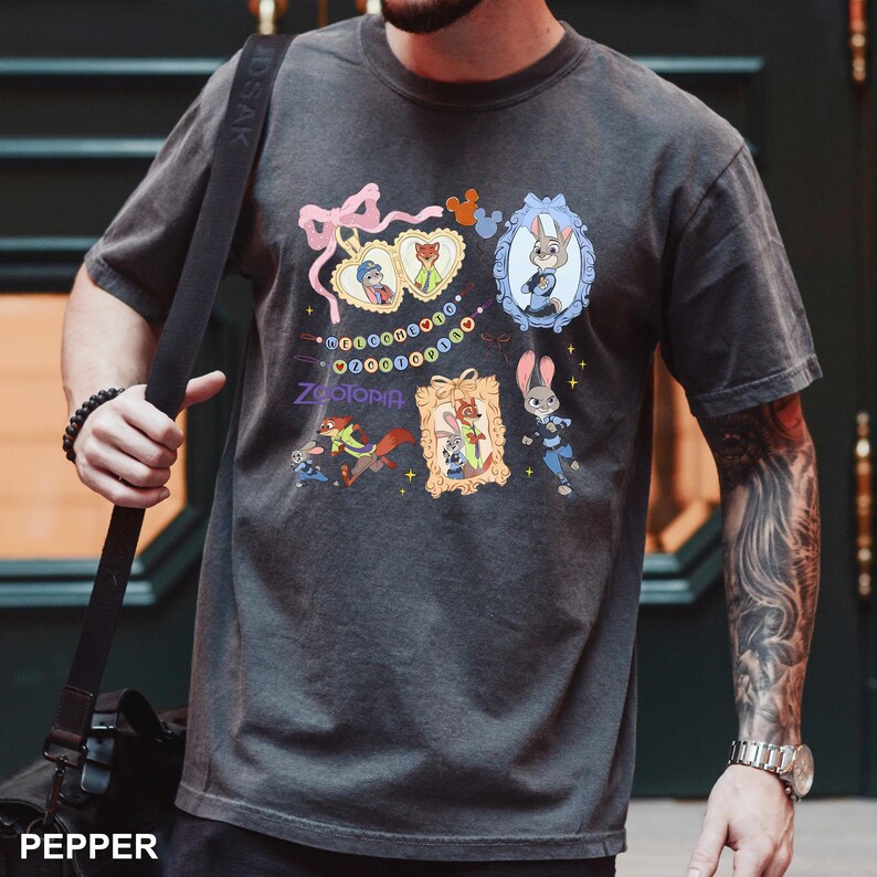A man wearing a gray t-shirt with a graphic design featuring cartoon animals and text.