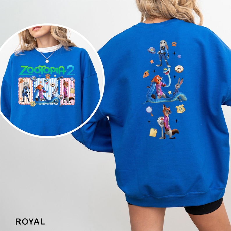 A person wearing a blue sweatshirt with a colorful graphic design featuring various cartoon characters and elements.