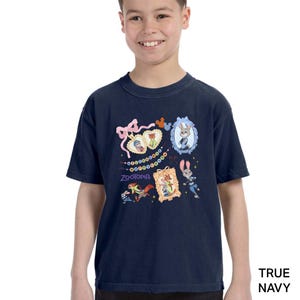 A young boy wearing a navy blue t-shirt with a colorful graphic design featuring cartoon characters and various decorative elements.