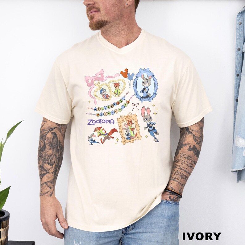 A man wearing a white t-shirt with a colorful graphic design featuring cartoon characters and various accessories.
