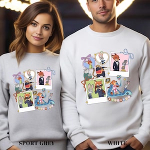 Two people wearing white sweatshirts with a colorful collage of cartoon animal characters and various other elements.