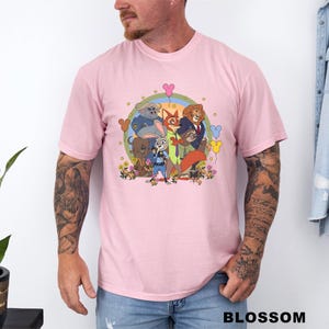 A man wearing a pink t-shirt with a colorful graphic of cartoon characters from the movie "Jumanji" and various other characters.