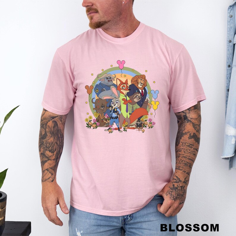 A man wearing a pink t-shirt with a colorful graphic of cartoon characters from the movie "Jumanji" and various other characters.