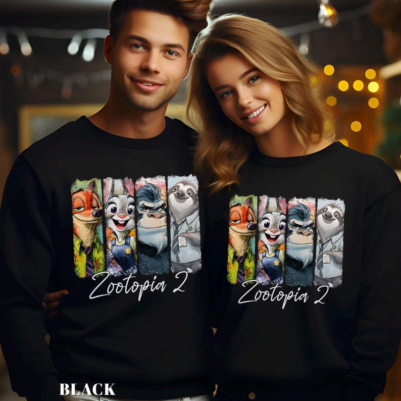 A man and a woman are standing next to each other, both wearing black sweatshirts with a graphic of cartoon animals from the movie "Zootopia 2".