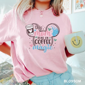 a woman in a pink shirt holding a coffee mug