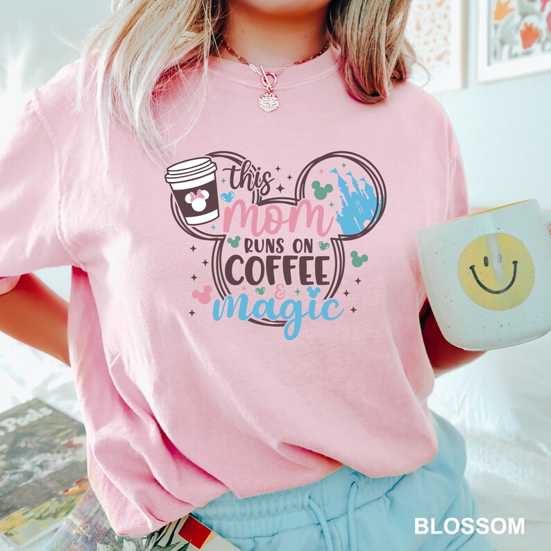 a woman in a pink shirt holding a coffee mug