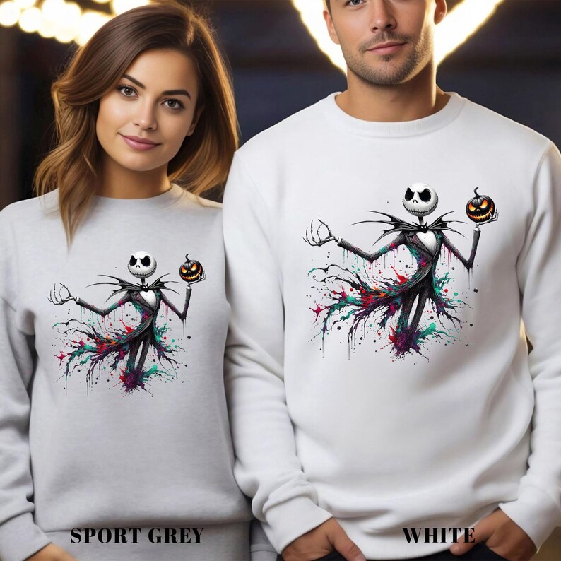 Two people wearing white sweatshirts with a graphic of a skeleton figure holding a jack-o-lantern.