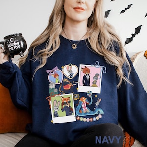 A woman wearing a navy blue sweatshirt with a graphic of cartoon animals and a mug with the text "Cocktail" on it.