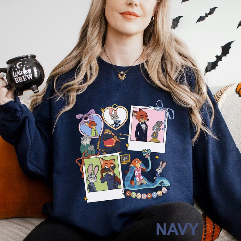 A woman wearing a navy blue sweatshirt with a graphic of cartoon animals and a mug with the text "Cocktail" on it.