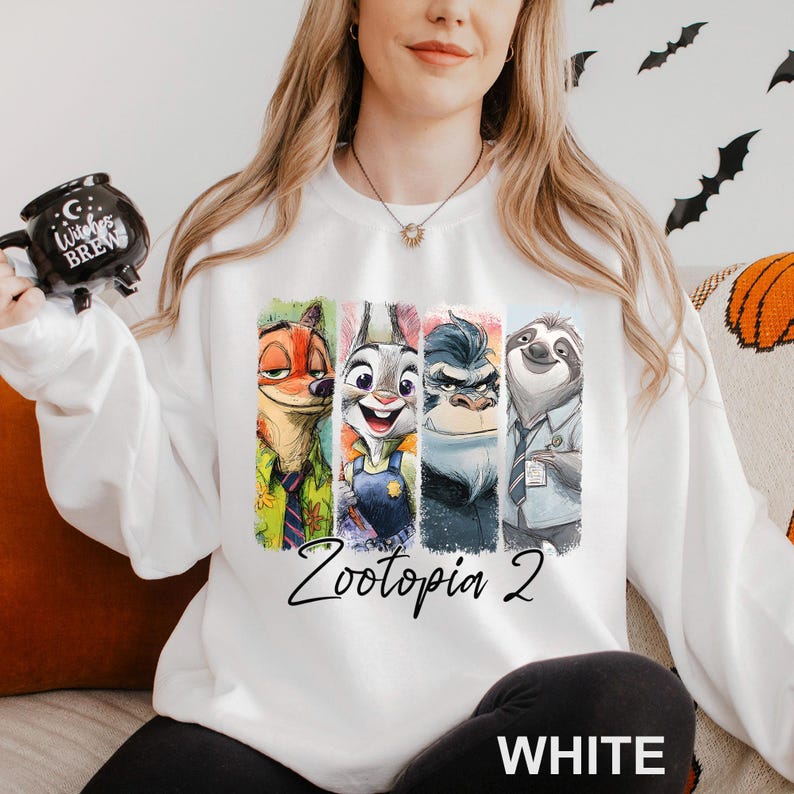 A woman wearing a white sweatshirt with a graphic of four cartoon animal characters from the movie "Zootopia" printed on it.