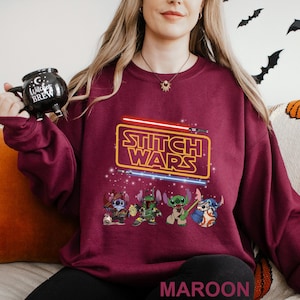 A woman wearing a maroon sweater with a Star Wars-themed design, including characters from the Star Wars franchise.