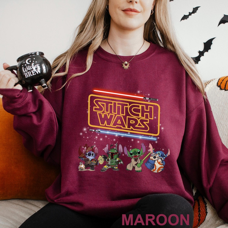 A woman wearing a maroon sweater with a Star Wars-themed design, including characters from the Star Wars franchise.