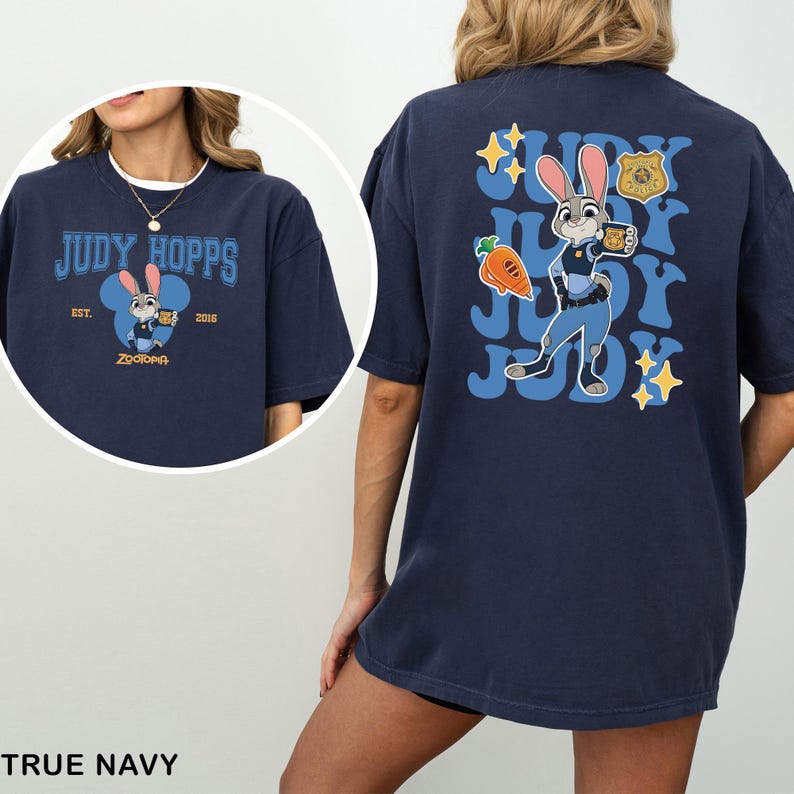 A woman wearing a navy blue t-shirt with a graphic of a cartoon rabbit character and text related to the character Judy Hopps.