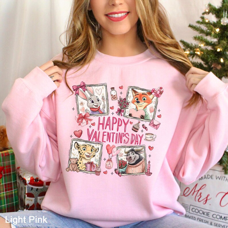 A woman wearing a pink sweatshirt with a graphic design featuring cartoon animal characters and the text "Happy Valentine's Day".