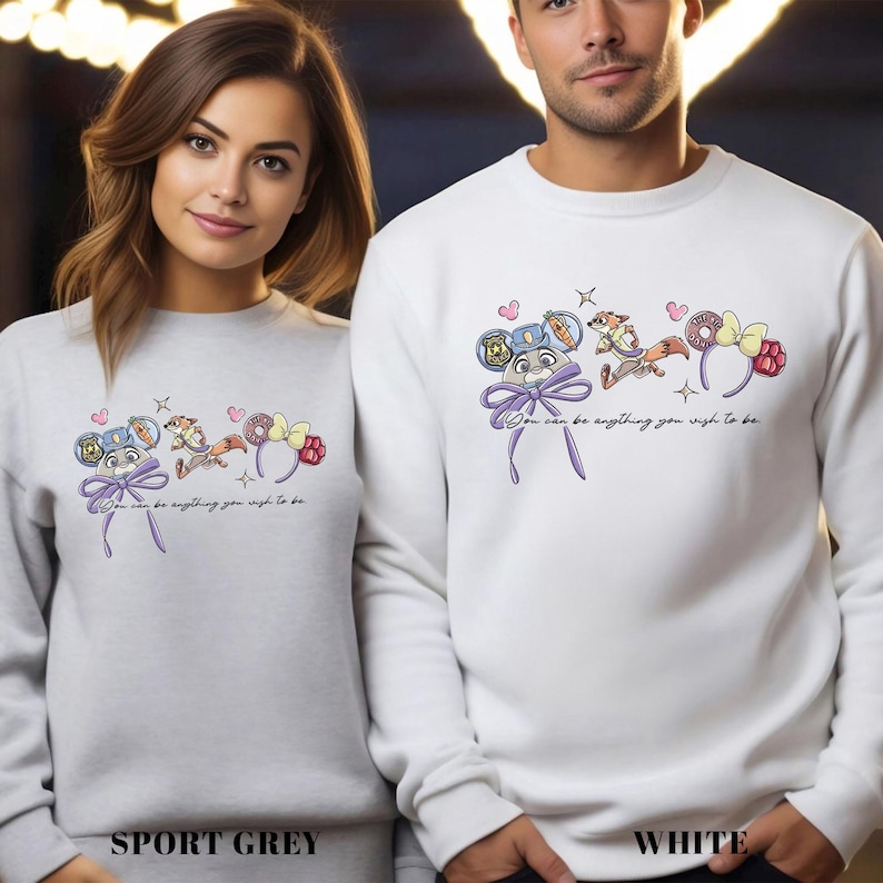 Two people wearing white sweatshirts with a graphic design on them.