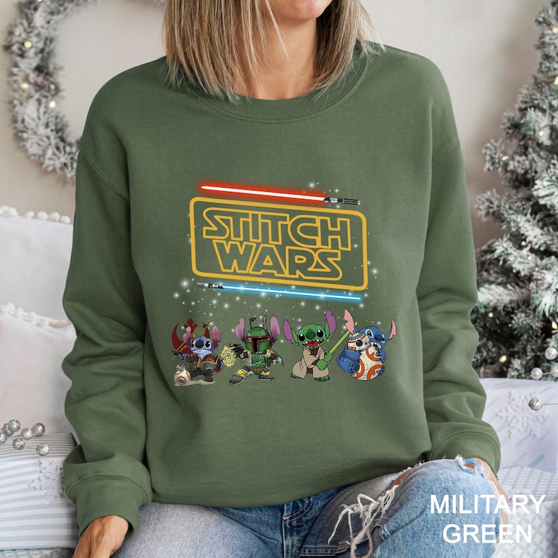 A woman wearing a green sweatshirt with a Star Wars-themed graphic design featuring characters from the Star Wars franchise.