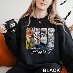 A woman wearing a black sweatshirt with a graphic of four cartoon animal characters from the movie "Zootopia" printed on it.
