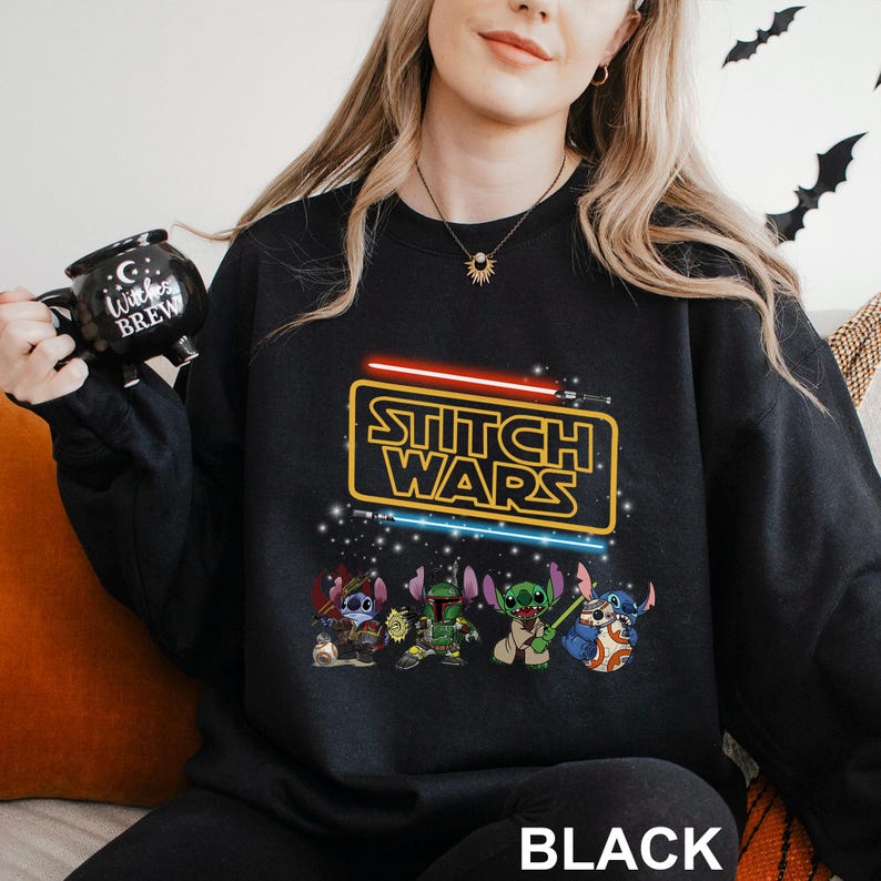 A woman wearing a black sweatshirt with a Star Wars-themed design, including characters from the Star Wars franchise.