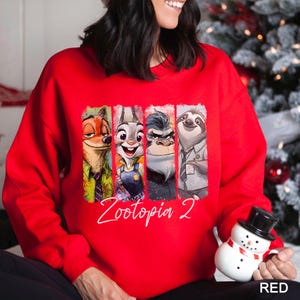 A woman wearing a red sweater with a graphic of four cartoon animal characters from the movie Zootopia.