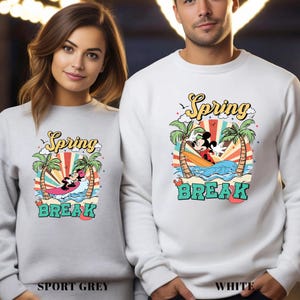 A woman and a man wearing matching white sweatshirts with a spring break theme.