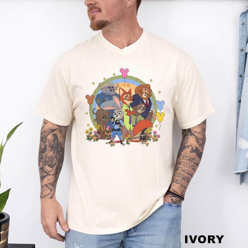 A man wearing a white t-shirt with a colorful graphic of cartoon characters and flowers.