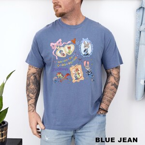 A man wearing a blue t-shirt with a cartoon character design and various other cartoon-style illustrations.
