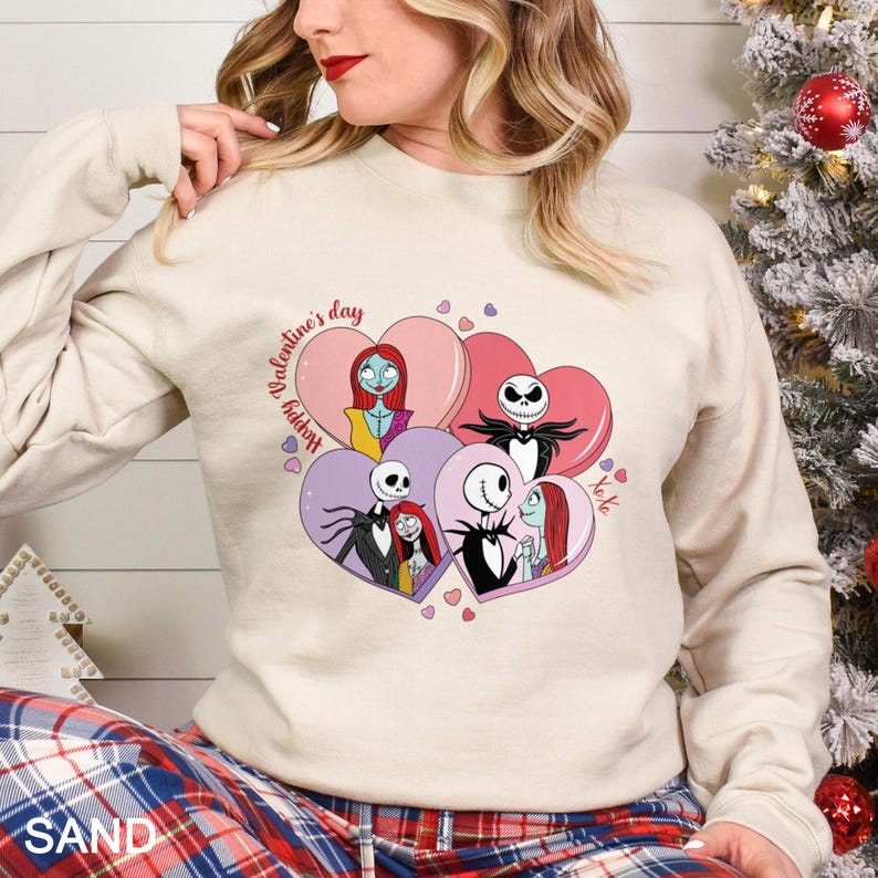 A woman wearing a white sweatshirt with a graphic of characters from the movie " Nightmare Before Christmas" and hearts around them.
